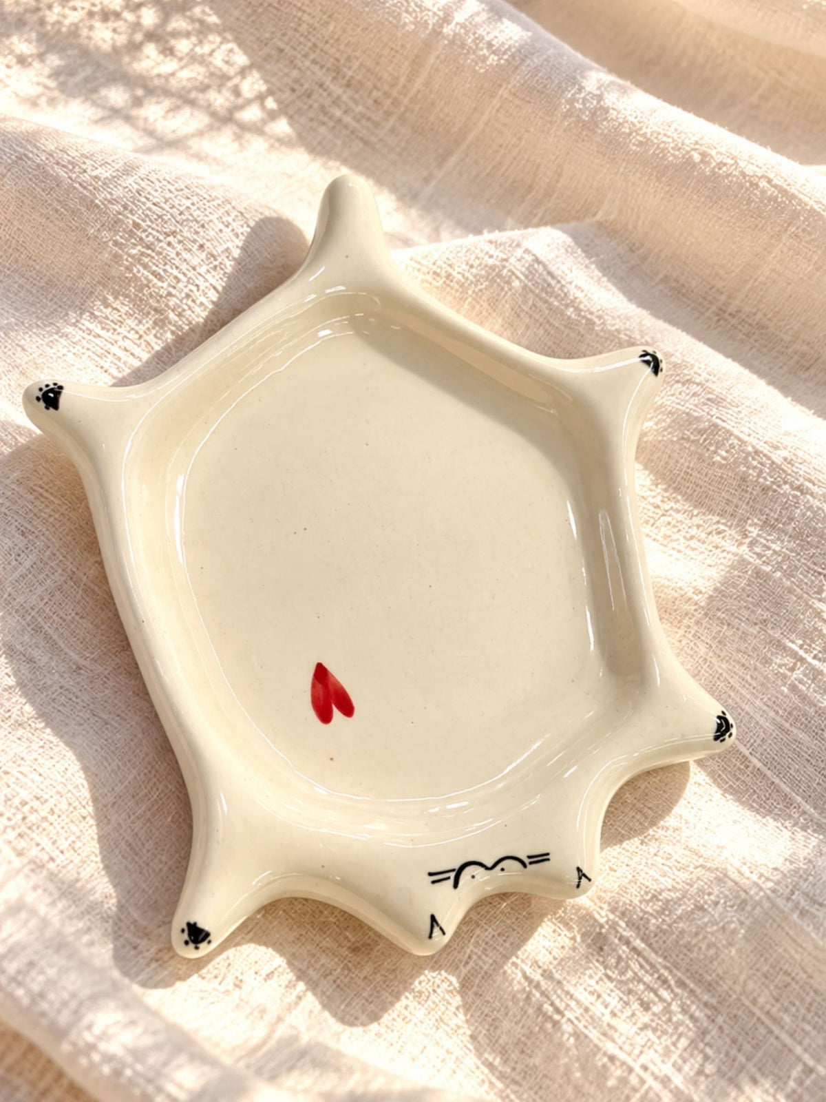 Cat-shaped ceramic saucer with painted paws and red heart by Chaak Design