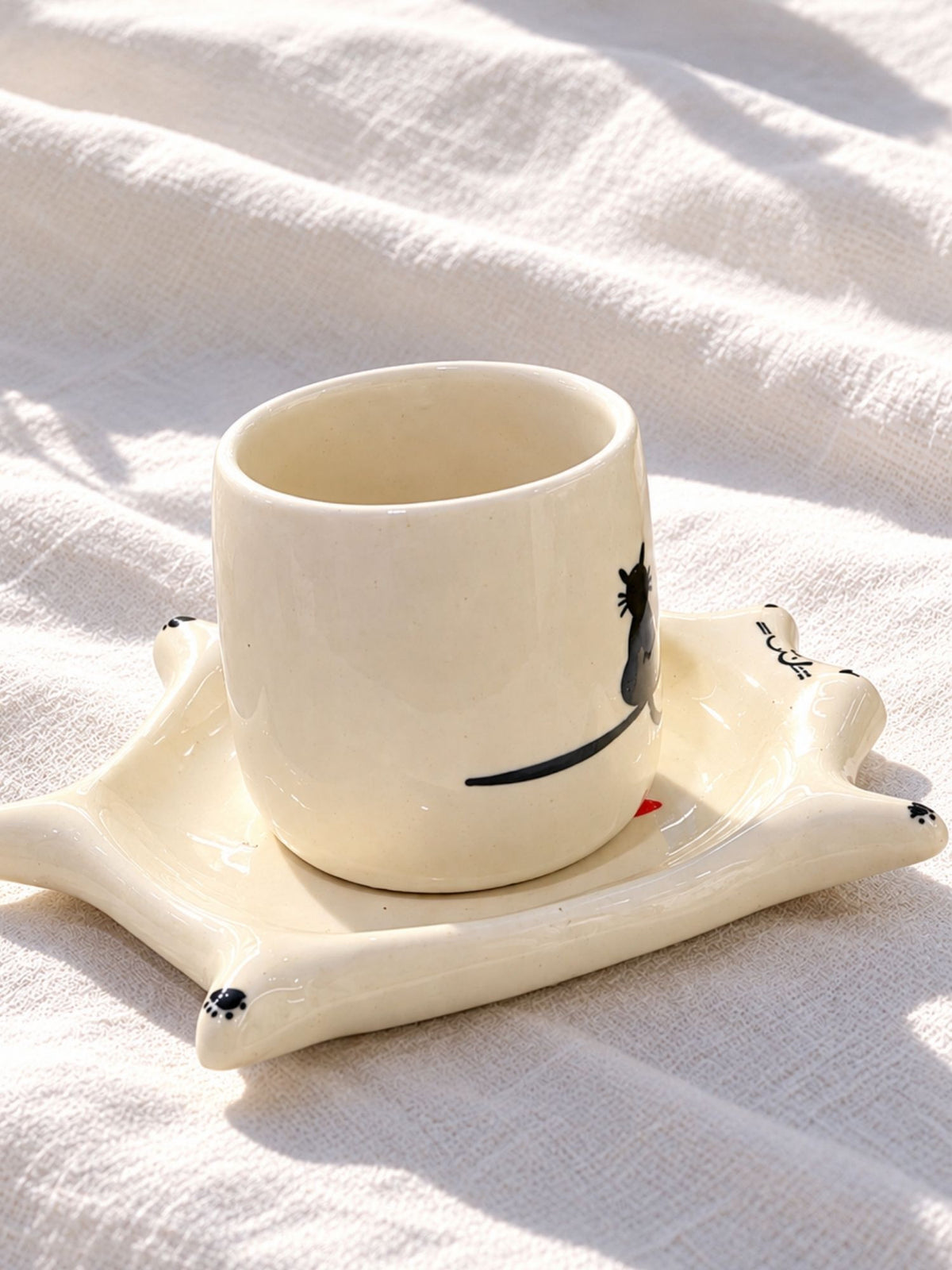 Hand-painted ceramic cup with black cat silhouette on cat saucer