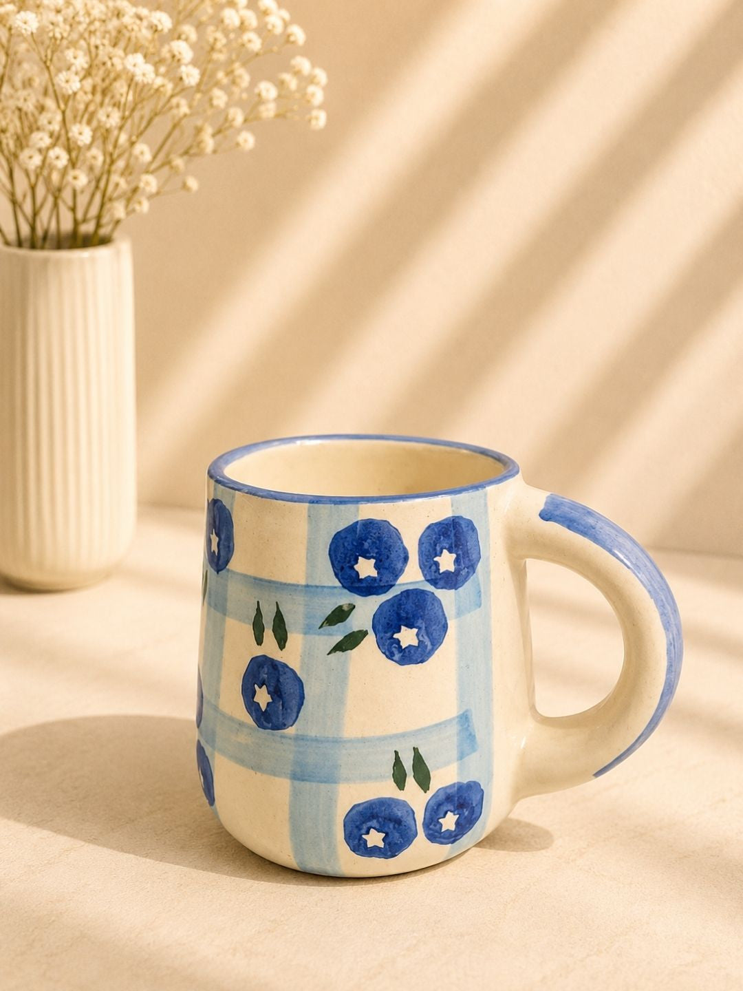 Handcrafted blueberry ceramic coffee mug with hand-painted blue berry motifs made by Khurja artisans.