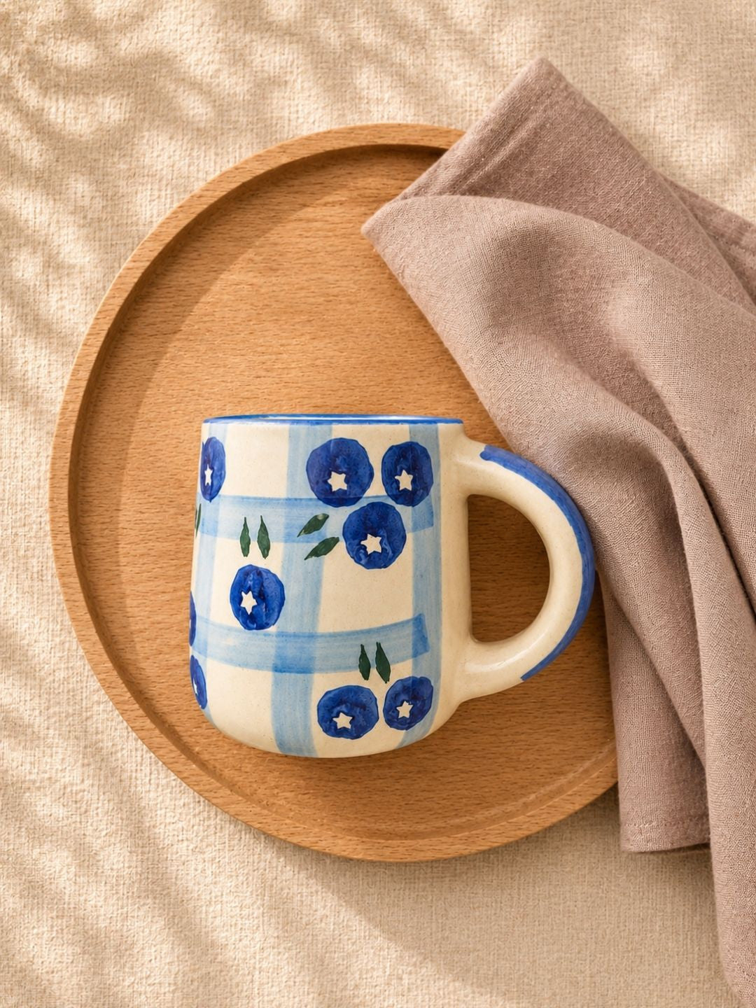 Hand-painted blue and white ceramic coffee mug inspired by blueberry motifs by Chaak Design.