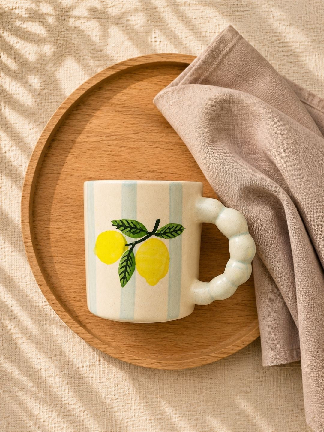 rtisan-made ceramic tea mug featuring yellow lemons and soft blue striped design.
