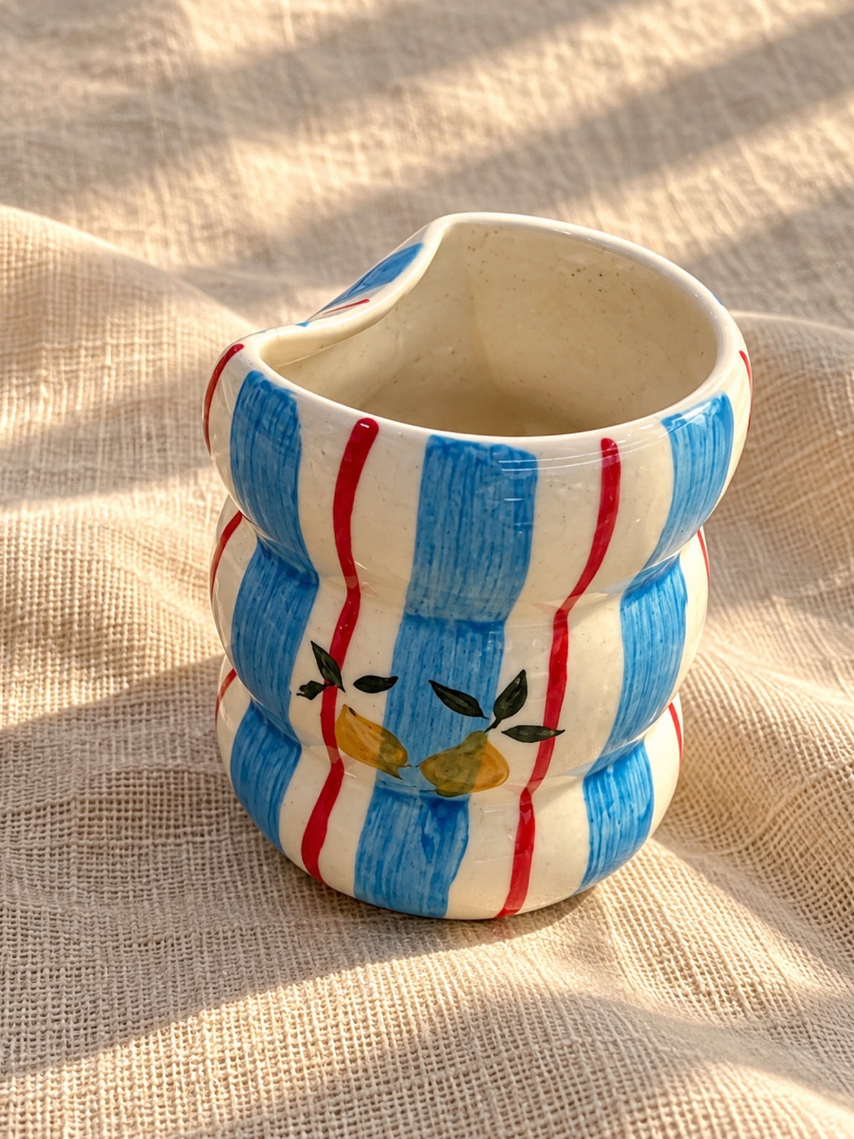 Blue and red striped ceramic bubble tumbler with lemon motif, top view of rim
