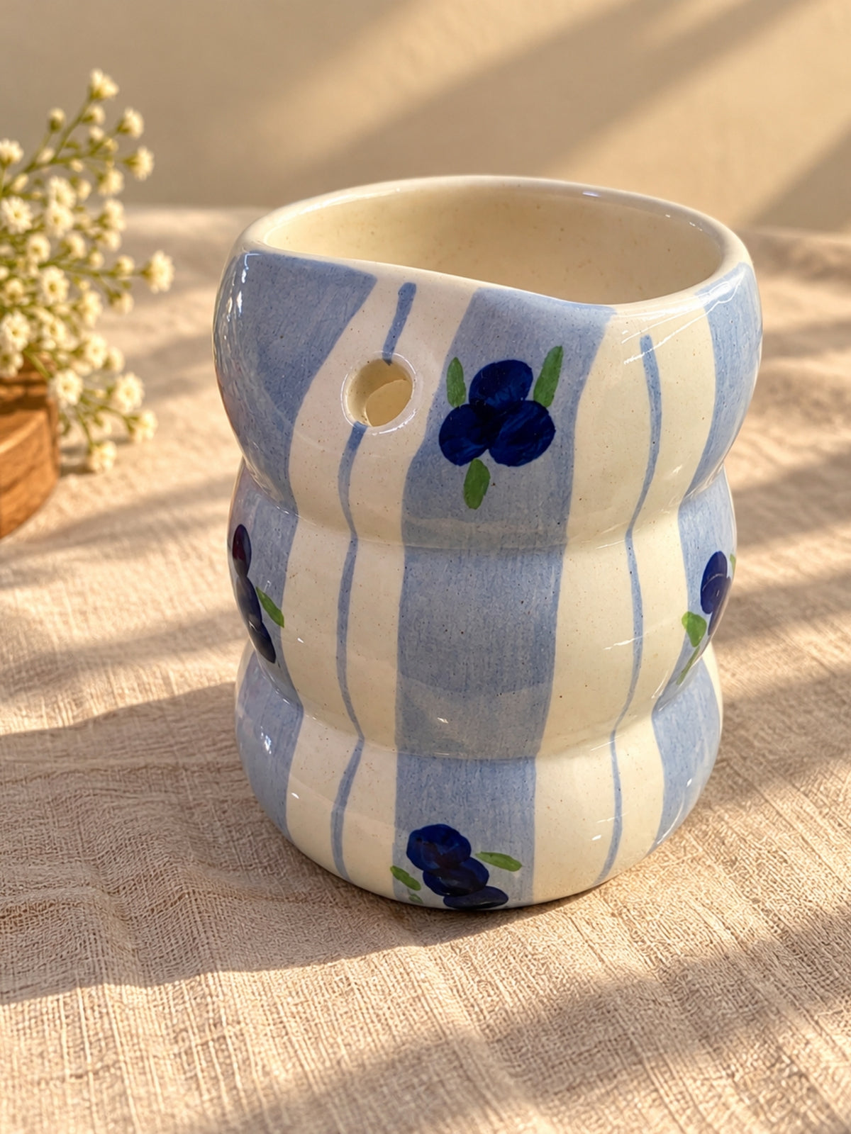 Hand-painted blueberry ceramic bubble tumbler showing built-in straw hole
